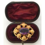 A large amethyst and gold Victorian brooch attract