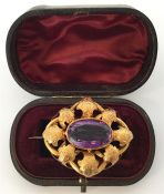 A large amethyst and gold Victorian brooch attract