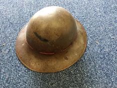 A Second World War old tin hat. Est. £20 - £30.