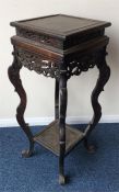 A Chinese hardwood stand with scroll decoration. E