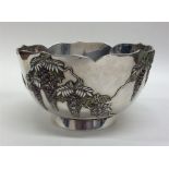 An Oriental silver bowl with enamel foliage on ped