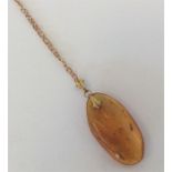 A small amber single stone pendant on fine link ch
