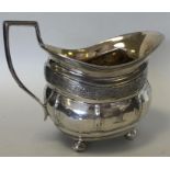 A Georgian silver bright cut cream jug with ball d