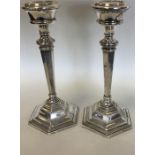A pair of silver tapering bedroom candlesticks of
