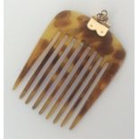 A small tortoiseshell and gold-mounted hair comb.