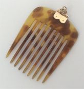 A small tortoiseshell and gold-mounted hair comb.