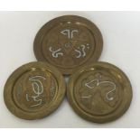 A set of three Eastern brass plates decorated with