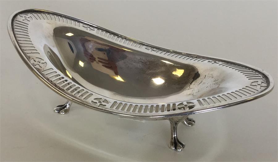 An Edwardian boat-shaped silver dish on four feet.