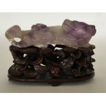 An unusual carved amethyst figure of a recumbent a