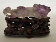 An unusual carved amethyst figure of a recumbent a