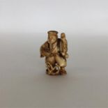 A carved ivory netsuke in the form of an Oriental