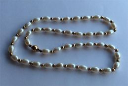 A gold and pearl necklace with barrel clasp. Appro