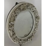 A miniature oval mirror decorated with flowers and