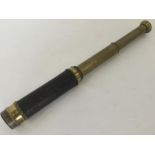 A brass mounted telescope with leather sleeve.
