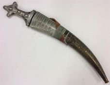 An Eastern white metal and brass-mounted dagger. E