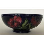 MOORCROFT: A blue-ground shallow bowl decorated wi