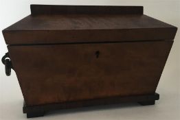 A mahogany tea caddy with fitted interior and hing