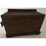 A mahogany tea caddy with fitted interior and hing