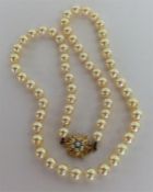 A graduated string of pearl beads with gold star-s