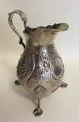 A Victorian embossed silver cream jug decorated wi