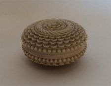 An Antique circular carved ivory box with threaded