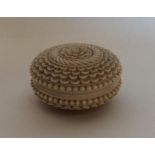 An Antique circular carved ivory box with threaded