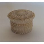 A small circular Antique ivory box decorated with