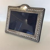 A modern rectangular silver picture frame with bea