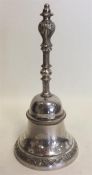 A heavy cast silver bell attractively decorated wi