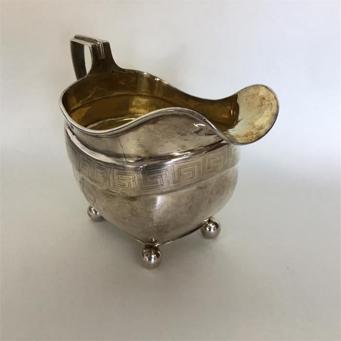 A good Georgian silver bright cut cream jug on bal