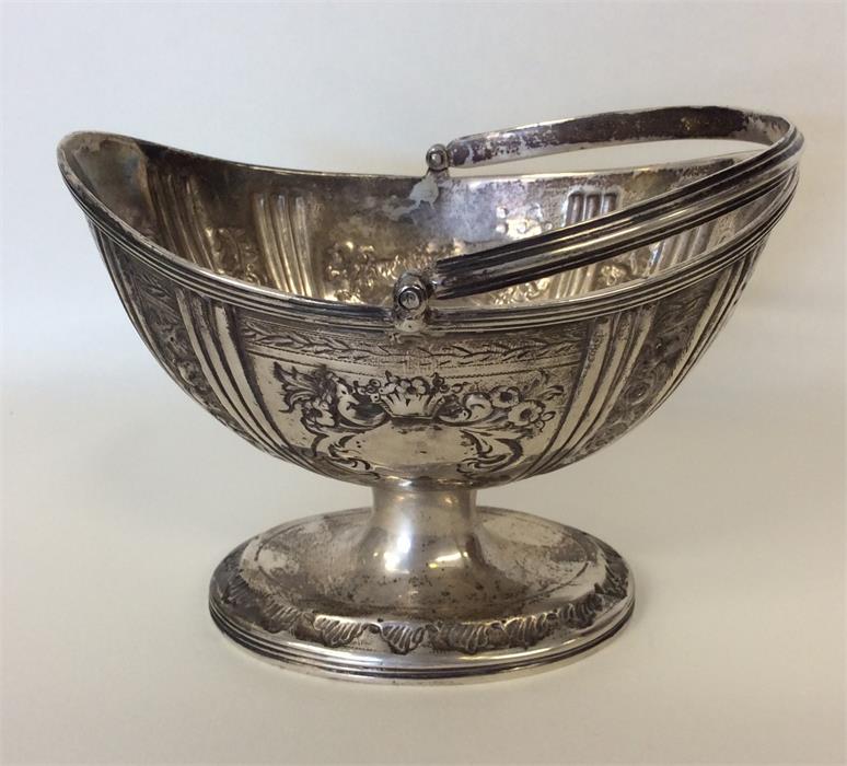 A Georgian silver embossed swing-handled basket wi