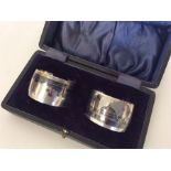 A boxed pair of Niello silver napkin rings decorat