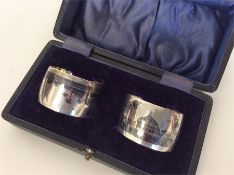 A boxed pair of Niello silver napkin rings decorat