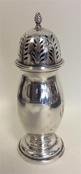 A stylish silver sugar caster with lift-off cover