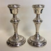 A pair of circular piano candlesticks with reeded