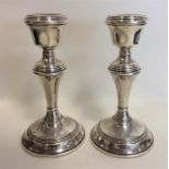 A pair of circular piano candlesticks with reeded