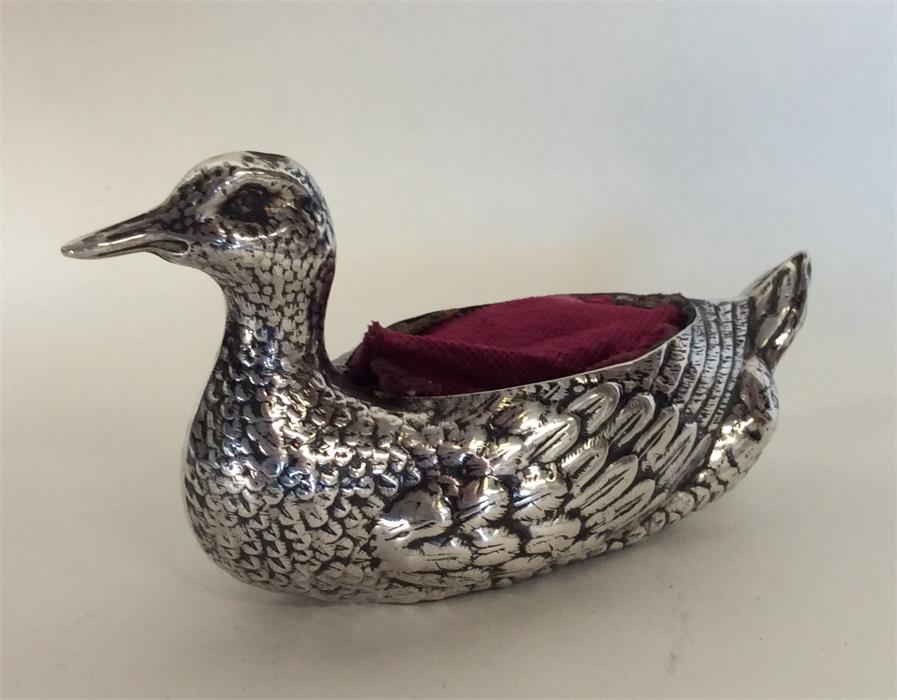 An unusual silver pin cushion in the form of a duc