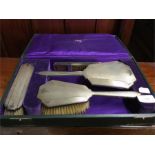 A stylish silver cased dressing table set.