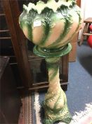 A large decorative green jardiniere on stand.