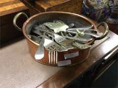 An old copper planter together with some cutlery e