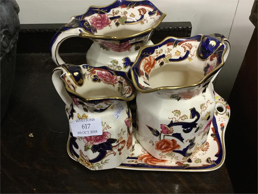 Three decorative Masons jugs on tray.