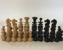 A carved ebony chess set decorated in typical form
