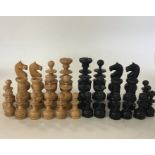 A carved ebony chess set decorated in typical form