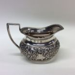 An attractive silver embossed cream jug with gadro