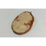 An oval cameo of a lady's head in plain gold frame