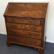 A Georgian four drawer bureau on bracket feet with