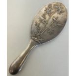 A Chinese silver hand mirror decorated with bamboo