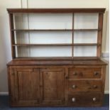 A large pine dresser with plank top and cupboard b