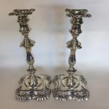 A tall pair of silver candlesticks with wavy edges