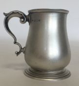 An Edwardian Georgian style silver mug on spreadin